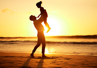 Image showing Father, girl and beach at sunset happy, silhouette of man and child together play on sand. Parent, ocean and sun, rising or setting over the horizon in nature, on vacation or family travel by the sea