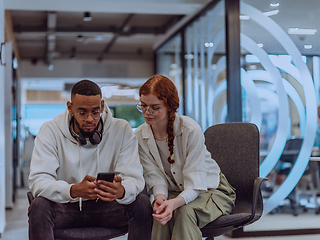 Image showing In a modern office African American young businessman and his businesswoman colleague, with her striking orange hair, engage in collaborative problem-solving sessions