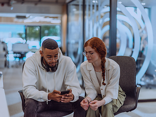 Image showing In a modern office African American young businessman and his businesswoman colleague, with her striking orange hair, engage in collaborative problem-solving sessions