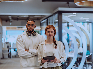 Image showing In a modern office African American young businessman and his businesswoman colleague, with her striking orange hair, engage in collaborative problem-solving sessions