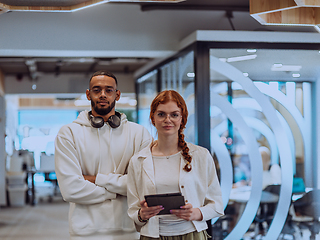 Image showing In a modern office African American young businessman and his businesswoman colleague, with her striking orange hair, engage in collaborative problem-solving sessions