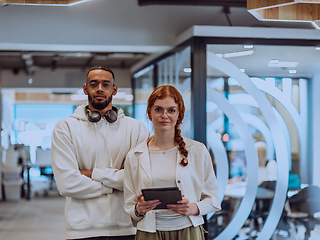 Image showing In a modern office African American young businessman and his businesswoman colleague, with her striking orange hair, engage in collaborative problem-solving sessions