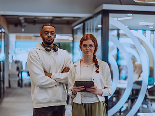 Image showing In a modern office African American young businessman and his businesswoman colleague, with her striking orange hair, engage in collaborative problem-solving sessions