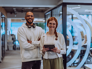 Image showing In a modern office African American young businessman and his businesswoman colleague, with her striking orange hair, engage in collaborative problem-solving sessions