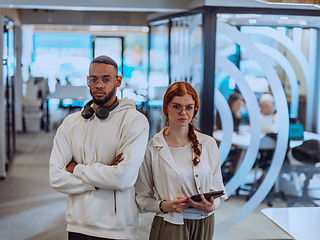 Image showing In a modern office African American young businessman and his businesswoman colleague, with her striking orange hair, engage in collaborative problem-solving sessions