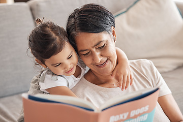 Image showing Education, learning and girl and grandmother reading a book on a sofa, relax and bonding in living room. Children, love and storytelling by senior woman enjoying fantasy story with curious grandchild