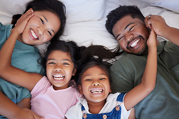 Image showing Happy, smile and portrait of family from above in bed bonding together in a bedroom at home. Happiness, love and interracial parents lying with girl children in holiday house room while on vacation.