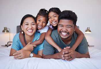 Image showing Portrait of a happy Asian family on the bed with a smile on their face. Multicultural Indian family in their bedroom smiling, laughing and having fun. Loving mom, dad and kids bond together at home
