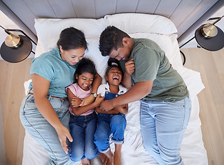 Image showing Family bed, home relax and parents in bedroom with children, care for comic kids and love in house together from above. Top view of girl siblings laughing with happy mother and father in the morning