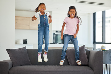 Image showing Excited girl kids jumping on living room sofa furniture at home for fun, energy and play games. Portrait crazy, happy and wild young children adhd, action and funny laughing bounce on lounge couch