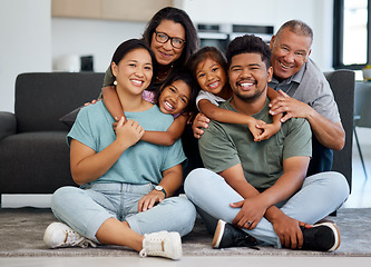 Image showing Big family portrait, children with grandparents with love, hug and smile together. Happy elderly mother, father and kids bonding together with adult children on the floor in the living room of house