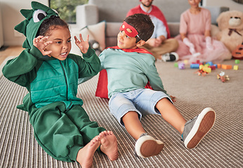 Image showing Family, halloween and children playing in costume on a floor in a living room, having fun and being creative. Superhero, dinosaur and creative kids bonding in character, excited and happy together