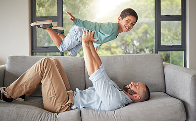 Image showing Children, family and love with a man and boy playing together on a sofa in the living room of their home. Father, son and kids with a male parent bonding with his child in their house with a smile