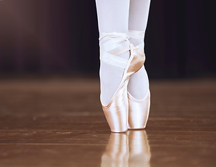 Image showing Ballet, dance and shoes with the feet of a ballerina or dancer dancing on a theater stage for a performance or show. Creative, art and training with an artist or performer practicing for a rehearsal