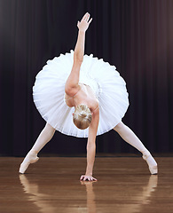 Image showing Ballet woman dancer, dancing on a theatre stage and doing a creative artistic performance. Training to dance means fitness, flexibility and balance. Routine is elegant, abstract and highly conceptual