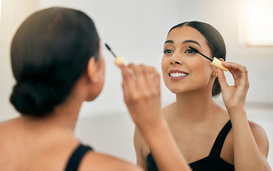 Image showing Woman, makeup and mascara in a mirror for beauty on her eye with a smile in a room. Young beautiful latino female with cosmetics and skincare daily routine on her face with a brush for fashion