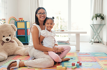 Image showing Portrait of a happy mother and child in a playroom playing with education building blocks. Happiness, care and smile of woman holding and sitting with her girl kid in colorful room with toys at home.