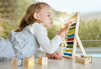 Image showing Education, abacus and girl learning math with a color tool while counting on the floor. Young child or student play mathematics or calculate game with educational toy for academic knowledge in house