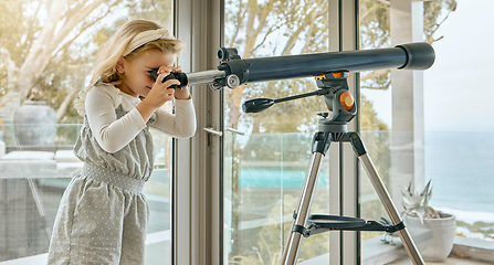 Image showing Children, telescope and astrology with a girl looking at the sky or stars through a scope in her house. Astronomy, science and imagination with a young female child stargazing in her home alone