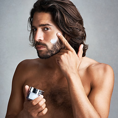 Image showing Portrait, skincare or cream with a shirtless man in studio on a gray background for his grooming routine. Beauty, facial and and the body of a handsome young person with antiaging lotion for his skin