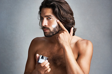 Image showing Portrait, skincare or lotion with the face of a man in studio on a gray background for his grooming routine. Beauty, facial and a handsome or shirtless young person with antiaging cream for his skin