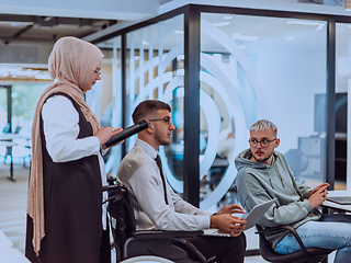 Image showing Young group of business people brainstorming together in a startup space, discussing business projects, investments, and solving challenges.