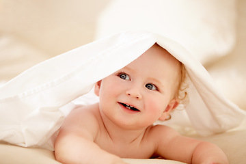 Image showing Smile, face and happy baby on a bed with blanket for playing, games or fun in a nursery room. Learning, child development and curious little boy kid in a bedroom with sheet cover while lying in house