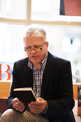 Image showing Reading, books and mature man in library for literature, information and knowledge in bookstore. Bookshelf, shopping and senior person with choice, decision and option for story, novel and learning