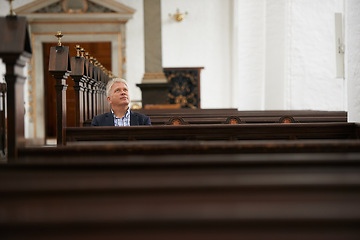 Image showing Senior man, sitting and church for religion, faith or pray at cathedral or holy grounds in Jesus Christ. Mature or religious male person looking up in sanctuary for salvation, forgiveness or worship