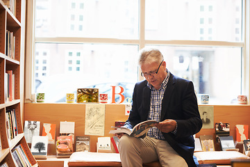 Image showing Senior man, library and author reading book for literature, knowledge or story at bookstore. Mature male person or information by bookshelf for novel, learning or wisdom in shopping or leisure