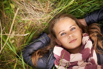 Image showing Serious, portrait and woman relax on grass in nature, countryside or field in environment. Above, face and person lying on lawn in backyard, garden or meadow with freedom outdoor in spring or summer