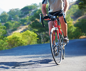 Image showing Cycling, fitness and legs of man on a bicycle in road for training, wellness or sport outdoor. Health, exercise or male athlete on a bike in a street for morning cardio, workout or marathon challenge