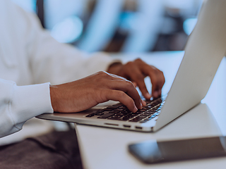 Image showing Close up photo of African American businessman is diligently working on his laptop, embodying determination, ambition, and productivity in his professional environmen