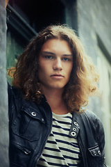 Image showing Man, portrait and serious outdoor for fashion, urban style and edgy outfit with confidence and pride. Person, face and young model with casual jacket, long hairstyle and stylish with calm expression