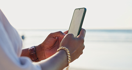 Image showing Closeup, beach and person with a smartphone, typing and connection with vacation, internet and contact. Outdoor, hands and traveller with a cellphone, seaside and holiday with message, app or texting