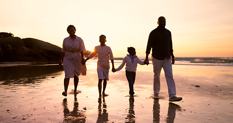 Image showing Family, walking and holding hands on beach at sunset in summer, holiday or vacation with love. Parents, children or support with care and travel with insurance or security together at sea or ocean