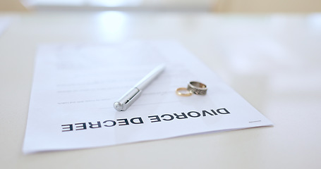 Image showing Divorce, contract and pen with wedding in office for signature, decision and break up of marriage. Closeup, document or legal paperwork and rings with trouble, problem or conflict in relationship