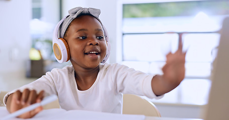 Image showing Black child, headphones and learning in video call, studying and homework in house. African kid in virtual class, distance education and listening to lecture, music and writing notes in home school