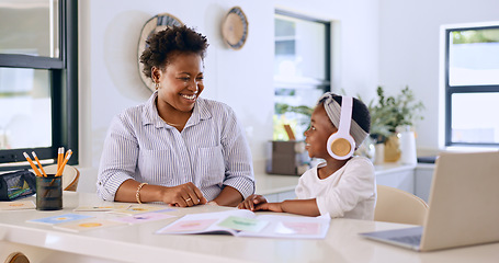 Image showing Child, woman or happy with headphones for learning, kitchen or home school for online education on project. Mother, daughter or smile by counter in distance study, technology or audio lesson in house