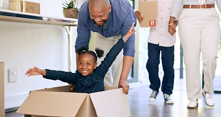 Image showing Black family, new home and push in box, smile and together in apartment or house. Girl, father and kid play in cardboard game, happy and real estate loan, moving and celebrate mortgage in property