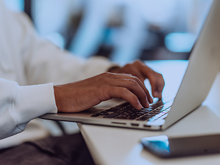 Image showing Close up photo of African American businessman is diligently working on his laptop, embodying determination, ambition, and productivity in his professional environmen