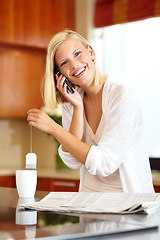 Image showing Woman, smile and phone call in kitchen, communication and newspaper or information at home. Female person, smartphone and conversation or chat, tea and hot drink for breaking news or laugh for joke