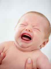 Image showing Closeup, baby and crying for upset in home for pain, unhappy or sadness with mother. Woman, hand and holding of infant for bath time, diaper or change in nursery for hygiene, health or cleanliness