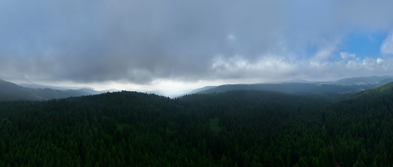 Image showing Aerial hyperlapse timelapse aerial view of clouds and mountains with green forest