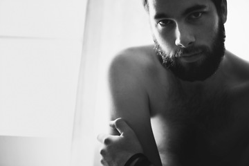 Image showing Man, bedroom and portrait with thinking and stress with black and white and beard at home. Art and male model in a house with a problem and anxiety with lonely grief and monochrome and mockup space