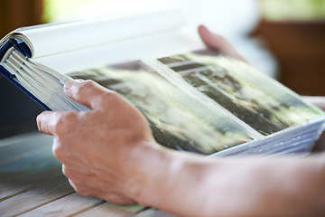 Image showing Photo album, photographs and hands of person for memory, reflection and nostalgia in home. Family pictures, thinking and closeup of photos in book to remember past, childhood and memories of youth