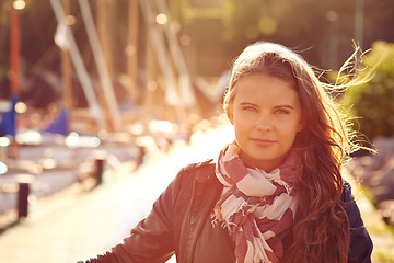 Image showing Portrait, fashion in summer and a woman in the harbor for travel, freedom or adventure with flare. Face, wind and style with a confident young person outdoor in a dock or shipyard for trendy clothing
