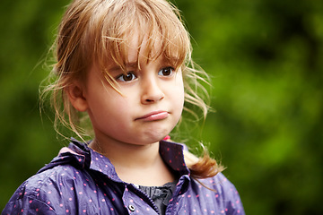 Image showing Girl, child and thinking outdoor with sad, raincoat and decision or choice to play in rain weather. Person, kid and emoji with disappointed expression, annoyed or moody in nature or backyard garden