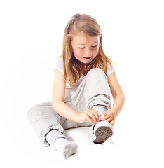 Image showing Shoes tie, kid and casual fashion with sneakers and youth with modern clothing in studio. Sitting, ground and young girl with socks and footwear with a smile from learning with white background