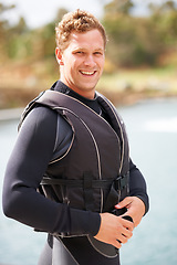 Image showing Man, ready and life jacket at lake, summer or portrait for extreme sports for fitness, exercise or workout. Person, happy and safety vest by river, nature or smile for pride, health or start training